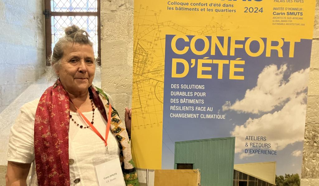 Carin Smuts, invitée d'honneur, devant l'affiche du colloque qui reprenait un visuel d'une de ses réalisations en Afrique du Sud.