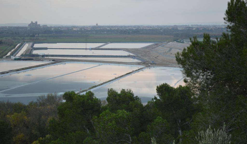 Les bassins de l’usine de traitement de l’uranium de Malvési avec, en arrière-plan, le centre-ville de Narbonne. © François Delotte